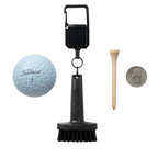 A golf club cleaning brush kit on a white background, including the SMILEY GOLF Mini Golf Brush with a Clip, a Titleist golf ball, a wooden tee, and a US quarter for scale.